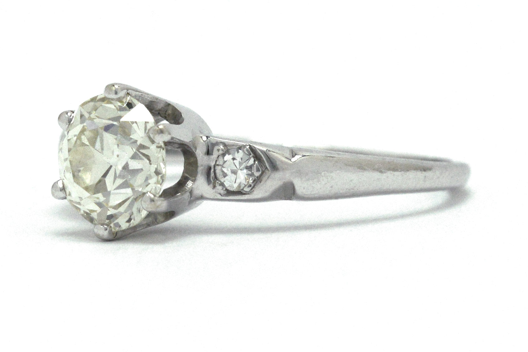 A Tiffany style solitaire engagement ring with a slightly yellow diamond.