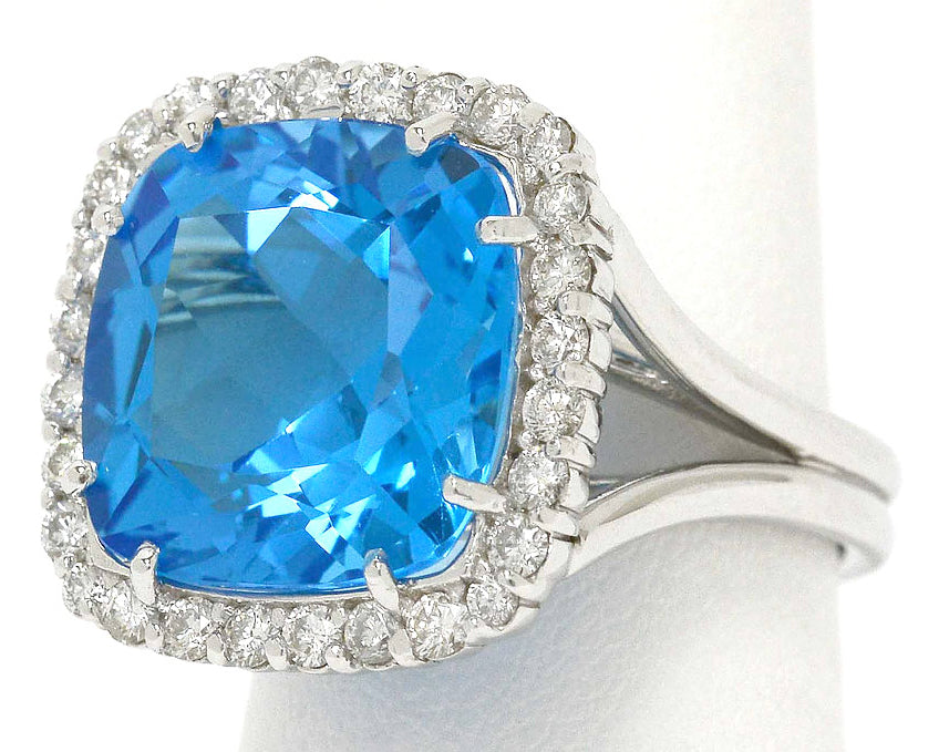 A large, 14 carat blue topaz cocktail ring with a square halo of diamonds.