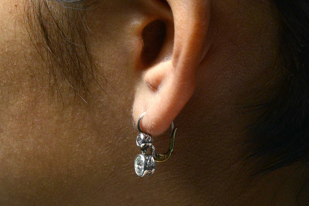 Two round brilliant diamonds dangle in these Victorian style lever back earrings.
