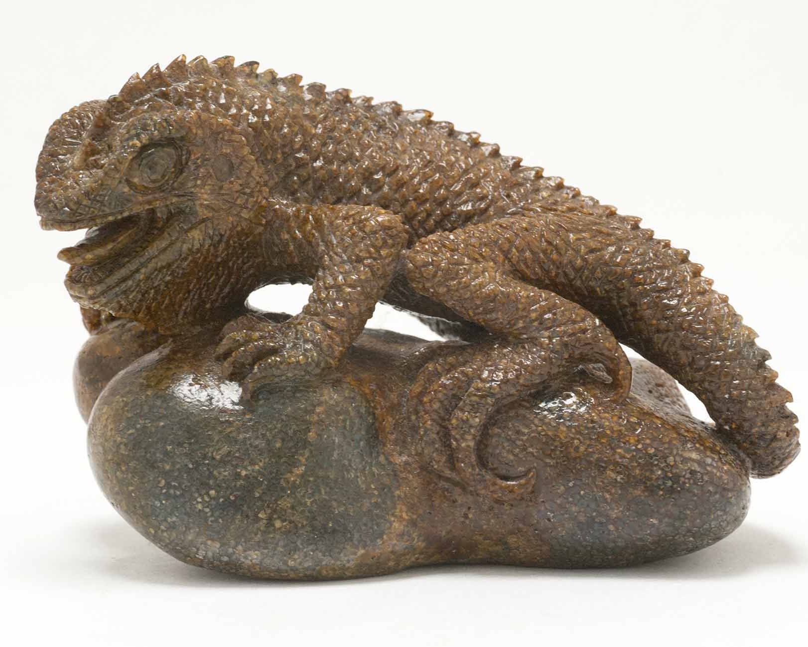 A perched lizard figure, carved out of fossilized whale bone by Ronald Stevens.