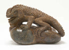 A perched lizard figure, carved out of fossilized whale bone by Ronald Stevens.