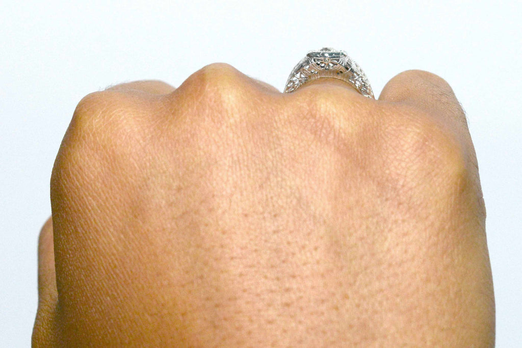 A diamond wedding ring with an 18k white gold filigree shank.
