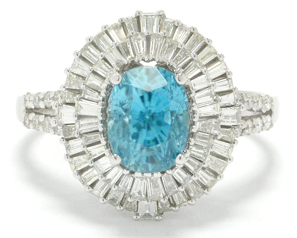 An oval faceted five carat blue zircon statement ring with two halos of diamonds.