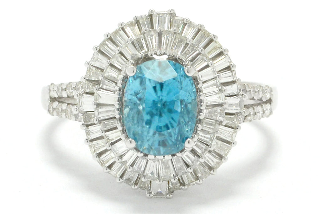 An oval faceted five carat blue zircon statement ring with two halos of diamonds.
