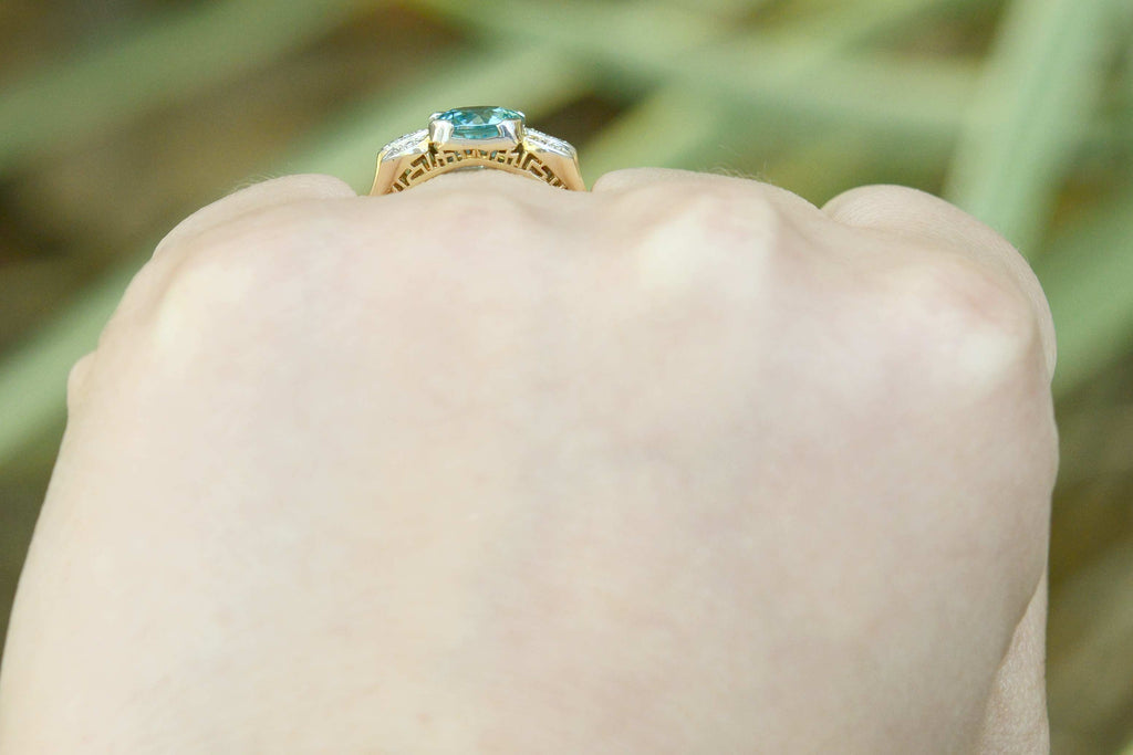 A neon blue zircon with great clarity set in a bridal ring with diamonds.